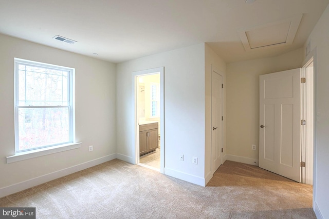 unfurnished bedroom featuring light colored carpet, visible vents, and baseboards