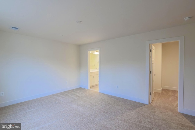 empty room with light colored carpet, visible vents, and baseboards