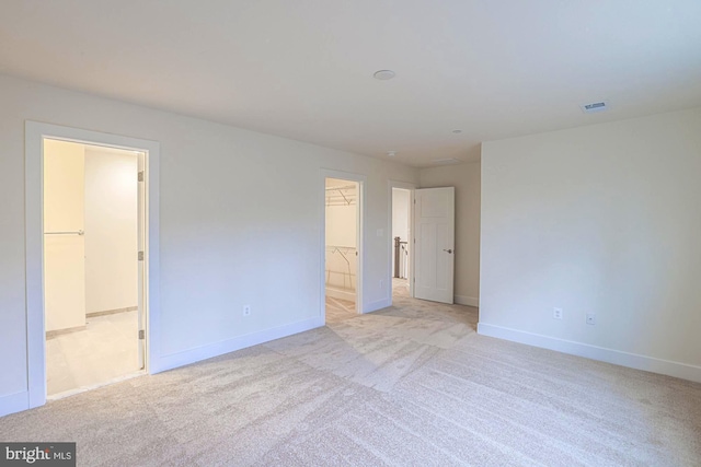 unfurnished bedroom with baseboards, visible vents, and light colored carpet