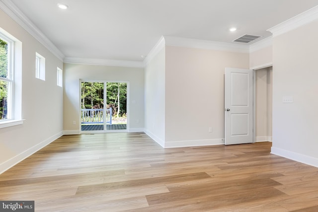 spare room featuring plenty of natural light, light hardwood / wood-style floors, and crown molding