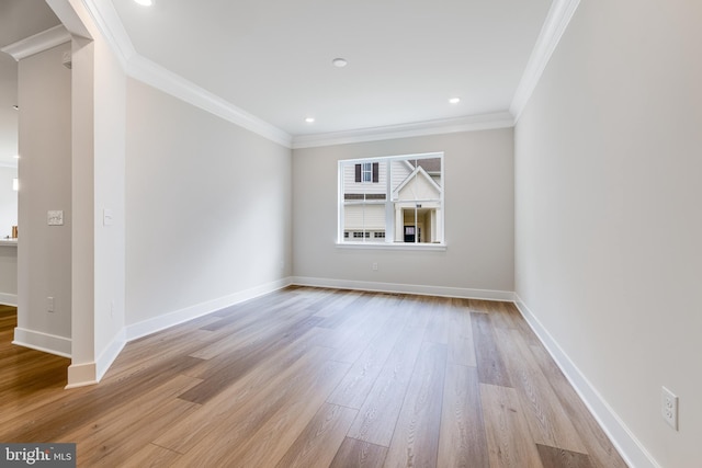 empty room with ornamental molding and light hardwood / wood-style floors