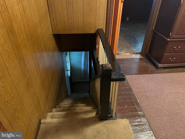 stairs featuring hardwood / wood-style floors and wood walls