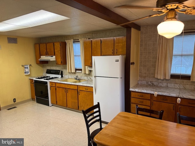 kitchen with ceiling fan, white appliances, sink, and tasteful backsplash