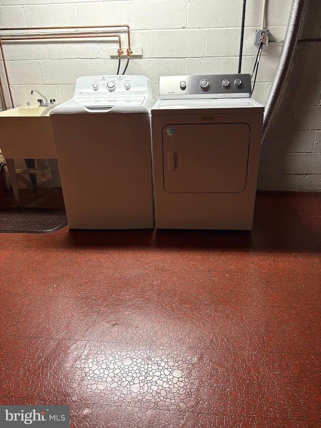 laundry area featuring washing machine and clothes dryer and sink