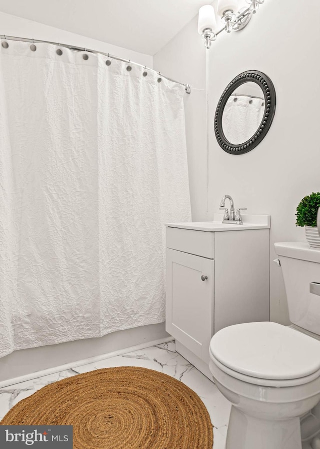 bathroom with vanity, marble finish floor, curtained shower, and toilet