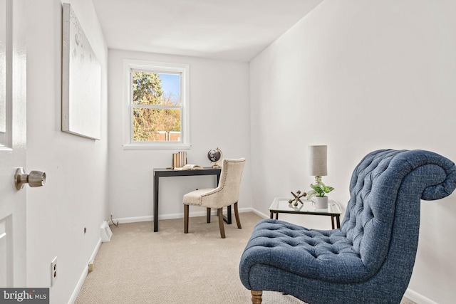 living area featuring light colored carpet and baseboards