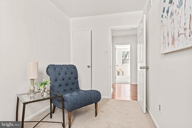 sitting room featuring carpet flooring and baseboards