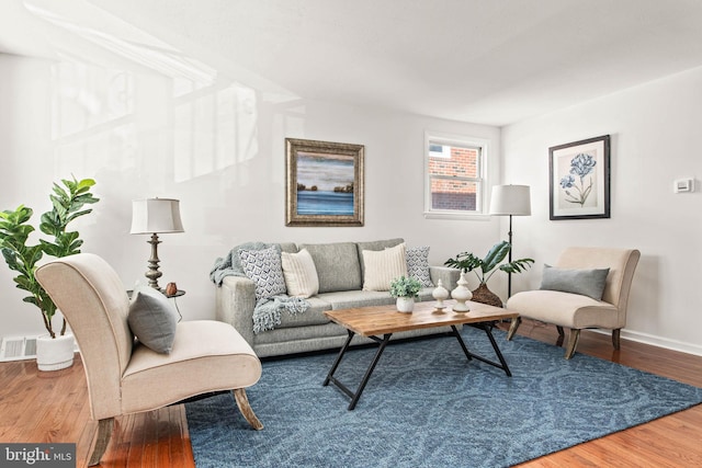 living room with baseboards, wood finished floors, and visible vents