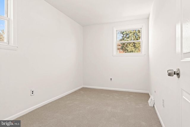 spare room with baseboards and carpet flooring