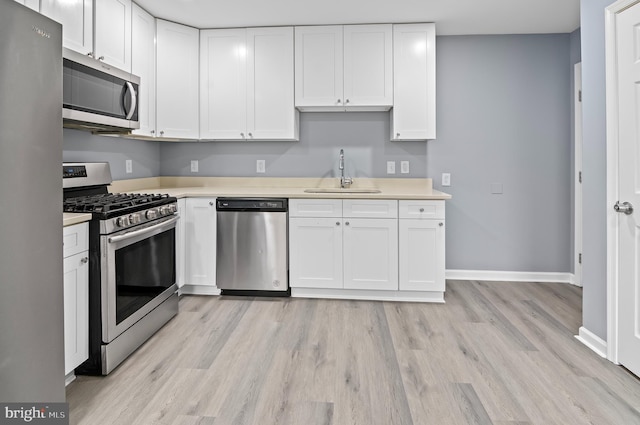 kitchen featuring white cabinets, light hardwood / wood-style floors, sink, and stainless steel appliances