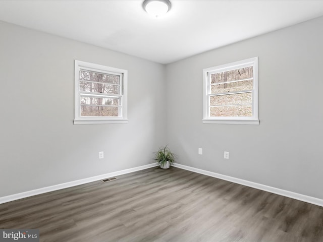 unfurnished room with dark wood-type flooring