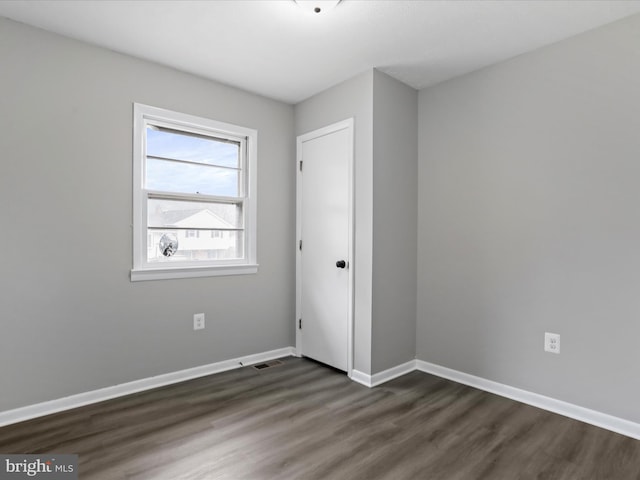 spare room with dark hardwood / wood-style floors