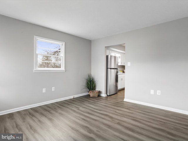 empty room with dark hardwood / wood-style flooring