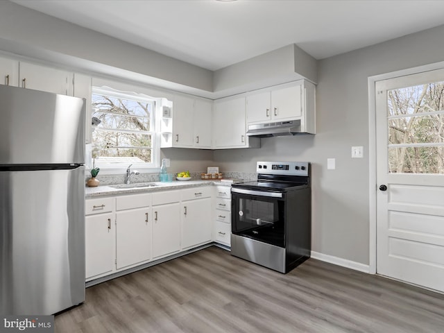 kitchen featuring white cabinetry, a healthy amount of sunlight, stainless steel appliances, and wood-type flooring