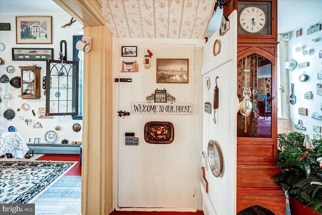 corridor with vaulted ceiling and hardwood / wood-style flooring