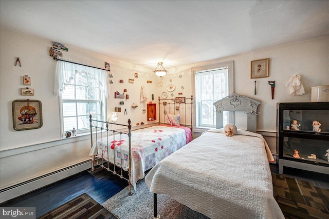 bedroom with dark hardwood / wood-style flooring, a baseboard radiator, and multiple windows