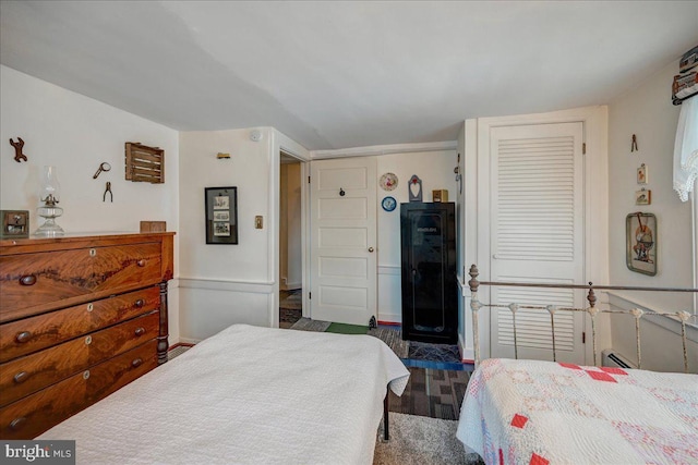 bedroom with a closet, dark hardwood / wood-style flooring, and a baseboard radiator