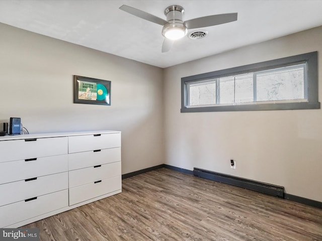 unfurnished room featuring a baseboard radiator, hardwood / wood-style flooring, and ceiling fan