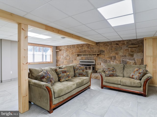 living room with a paneled ceiling and a wood stove