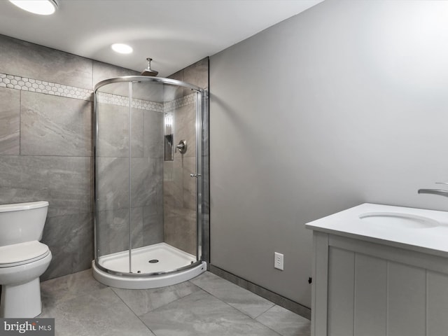 bathroom with vanity, toilet, and a shower with shower door