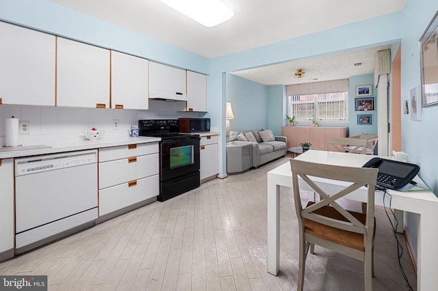 kitchen featuring decorative backsplash, white cabinets, black appliances, and light wood-type flooring