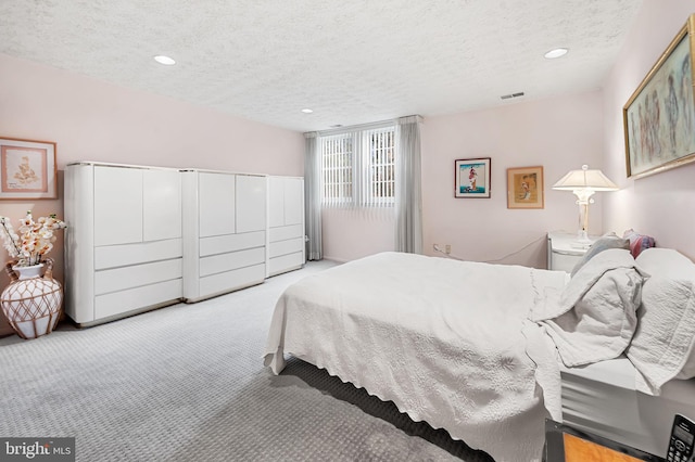 carpeted bedroom featuring a textured ceiling