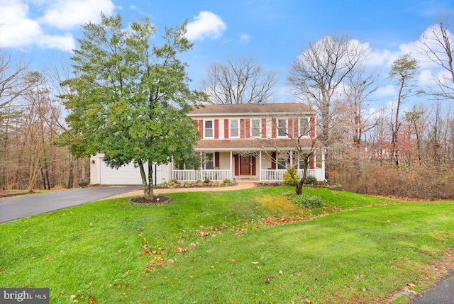 colonial house featuring a porch and a front yard