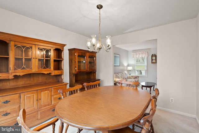 carpeted dining room featuring a chandelier