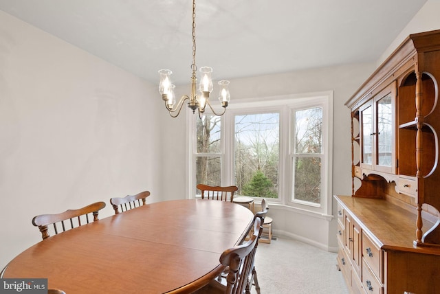 dining area featuring light carpet and a chandelier