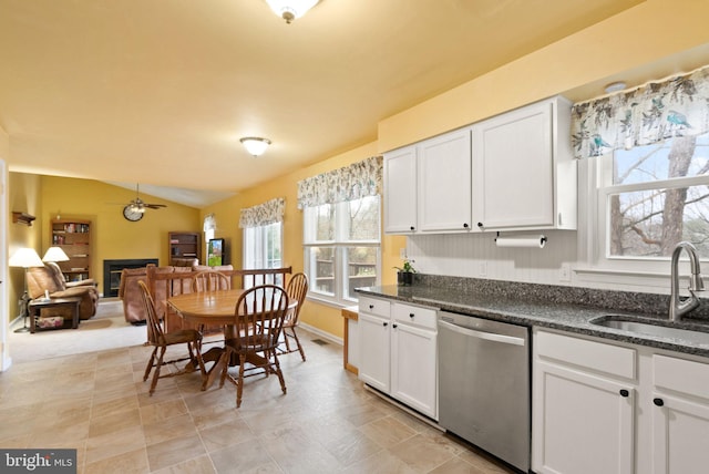 kitchen featuring dishwasher, white cabinets, sink, vaulted ceiling, and ceiling fan