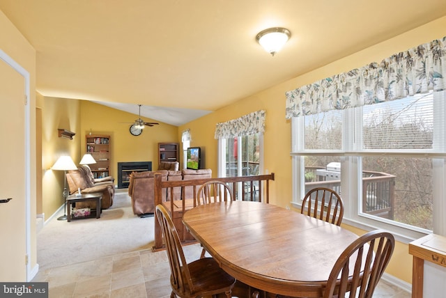 dining area with ceiling fan, lofted ceiling, and light carpet