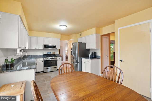 kitchen featuring white cabinets, dark stone countertops, sink, and stainless steel appliances