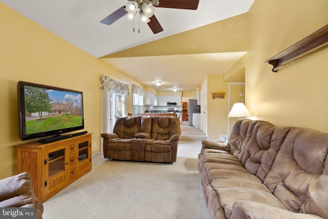 carpeted living room with ceiling fan and lofted ceiling