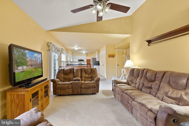 carpeted living room with ceiling fan and high vaulted ceiling