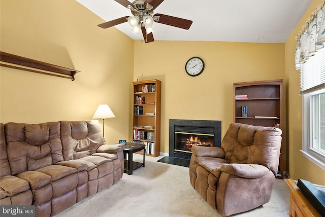 living room with ceiling fan, light colored carpet, and vaulted ceiling