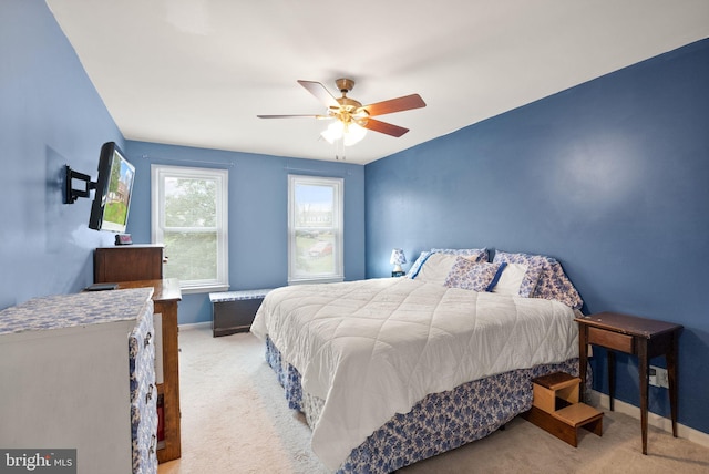 bedroom with ceiling fan and light carpet