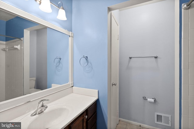 bathroom featuring tile patterned floors, vanity, toilet, and a shower