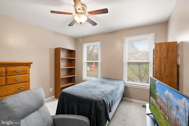 bedroom with light carpet, multiple windows, and ceiling fan