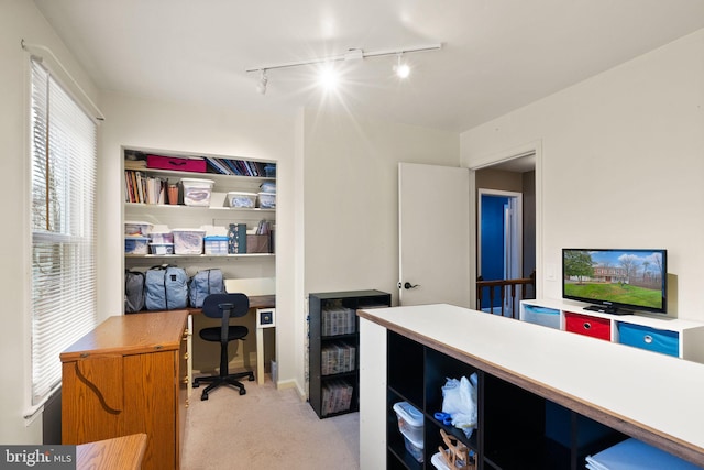 carpeted office space featuring rail lighting