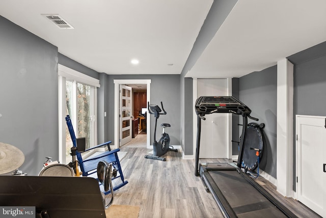 exercise room featuring light wood-type flooring