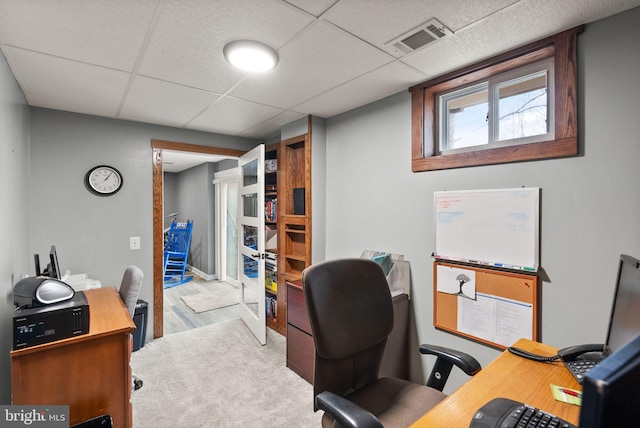 home office with light hardwood / wood-style floors and a drop ceiling