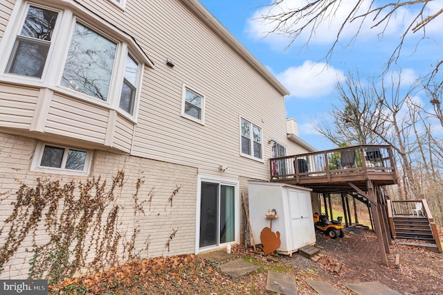 view of side of property with a shed and a wooden deck