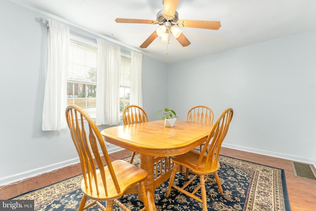 dining space with wood-type flooring and ceiling fan