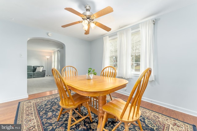 dining space featuring wood-type flooring and ceiling fan