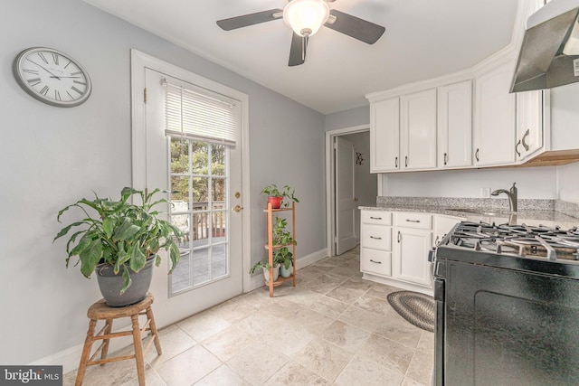 kitchen with white cabinets, gas range, ceiling fan, light stone counters, and extractor fan