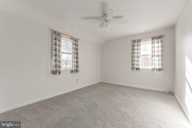 carpeted empty room featuring plenty of natural light, lofted ceiling, and ceiling fan