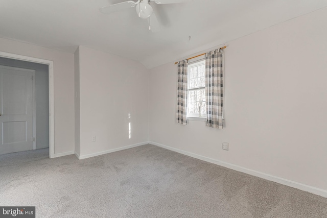 carpeted spare room featuring vaulted ceiling and ceiling fan