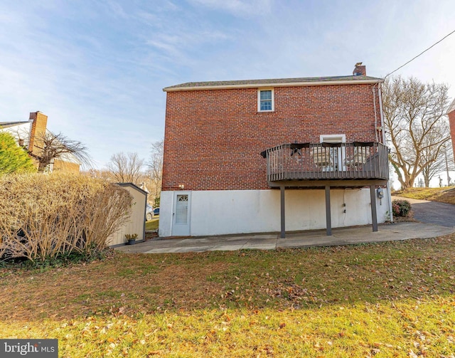 rear view of property with a patio area, a yard, and a wooden deck