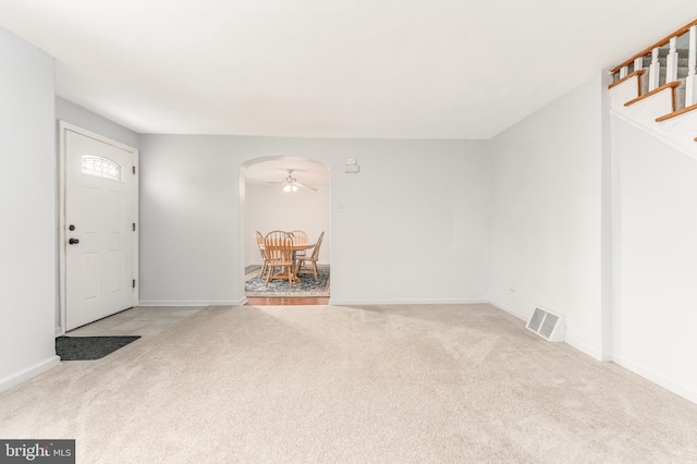 foyer entrance with light carpet and ceiling fan