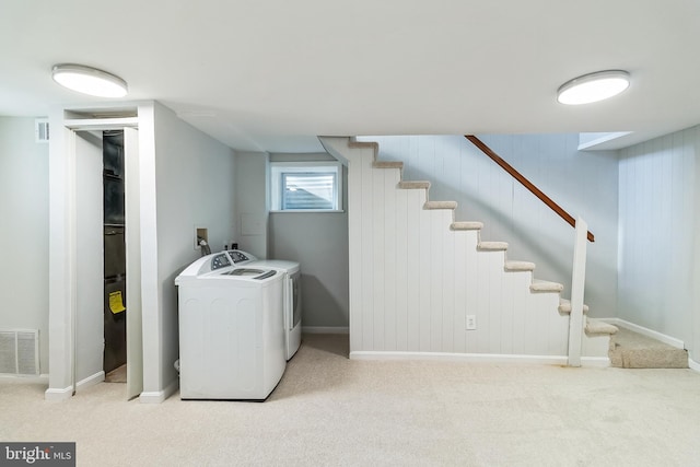 laundry room with laundry area, carpet floors, washing machine and clothes dryer, and visible vents